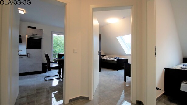 A modern apartment with a kitchen, dining area, and a bedroom with a skylight. - Overath Luxus Apartments (Overath)