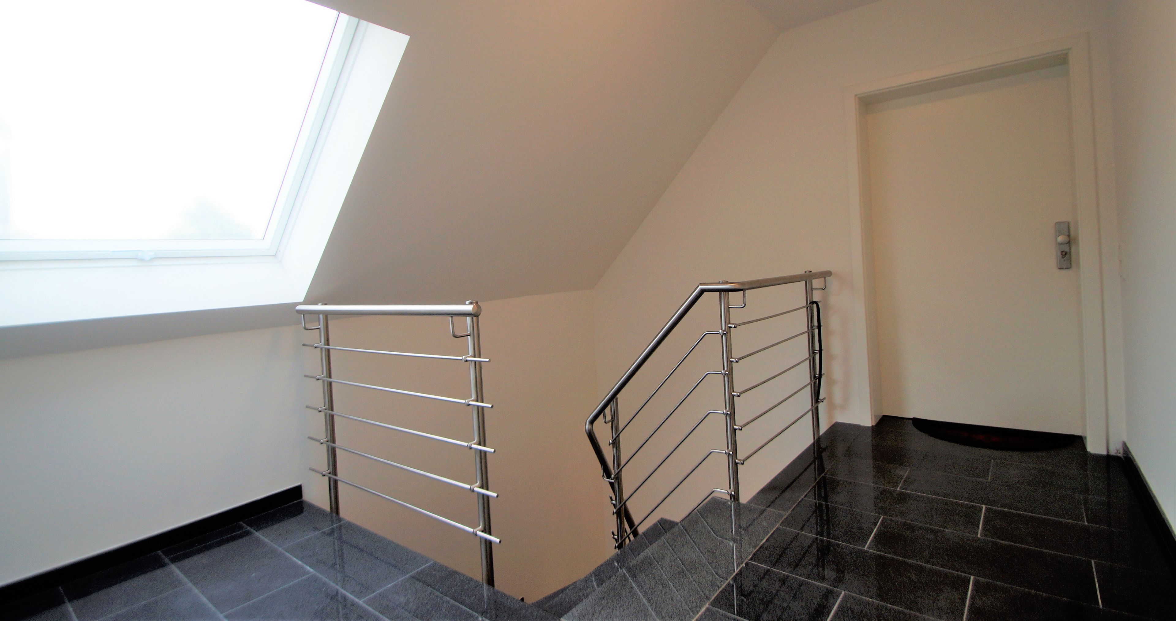 A staircase with metal railings, a window, and a door.