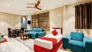 Una sala de estar moderna con un sofá, una mesa de centro, un televisor y un ventilador de techo.