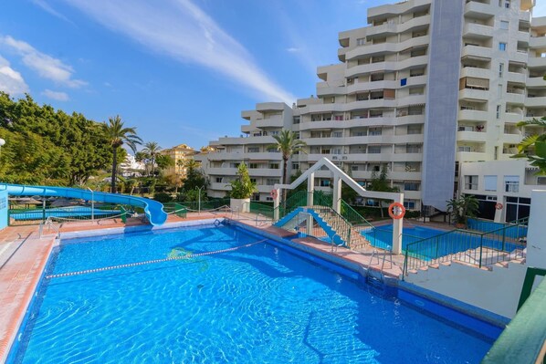 Una piscina al aire libre, una piscina climatizada, tumbonas