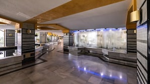 A spacious lobby with a central water feature, tiled walls, and a polished floor. - Benal Beach 121 - Modern First Line Beach 2BR Apartment in Benal Beach Resort. (Benalmádena)