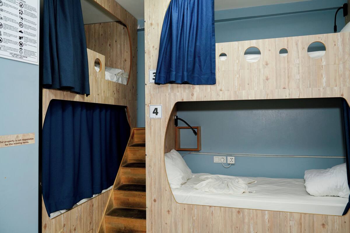 Habitación con literas, interior de madera, una escalera y un cartel que indica el número 4.