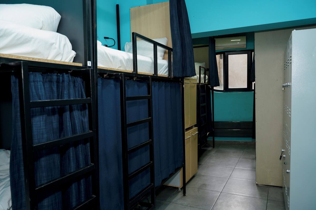 Un dormitorio con literas, un armario y una puerta que da a otra habitación.