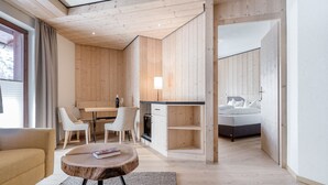 Un espacio habitable moderno y de concepto abierto, con techo de madera, zona de comedor con sillas, cocina y dormitorio con cama.