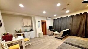 Un espai vital compacte amb cuineta, zona de menjador, sofà i televisió.