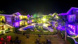 A resort with multiple buildings, a swimming pool, and outdoor seating areas. - Maulik Mansion Resort (Ramnagar)