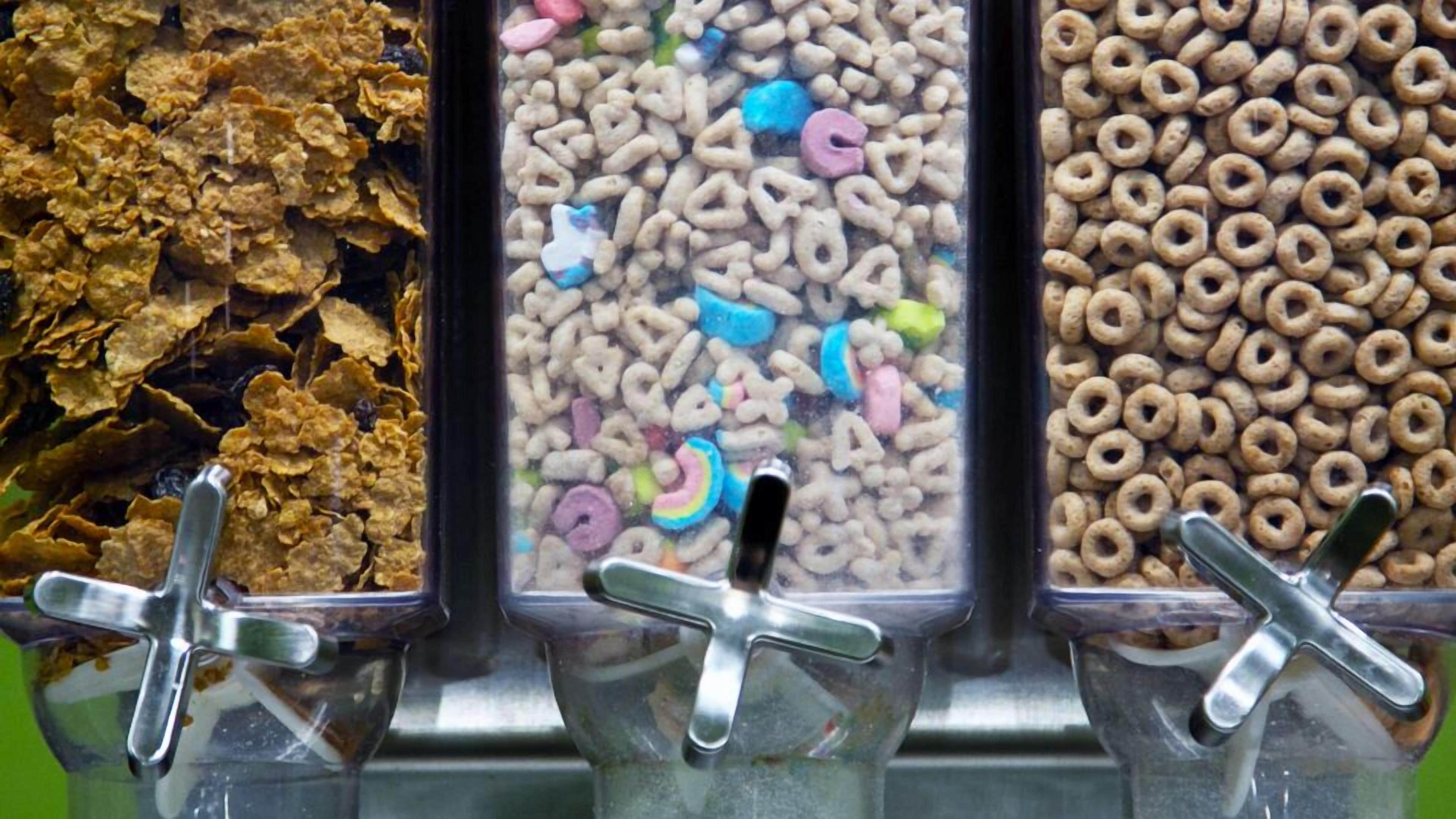 Een cornflakesmachine met drie vakken voor verschillende soorten ontbijtgranen.