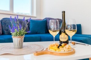 Ein Tisch mit zwei Weingläsern, einer Weinflasche und einer Platte mit Käse und Früchten.