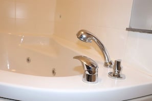 A white bathtub with chrome fixtures in a bathroom. - Struer Town Apartment (Struer)