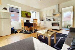 A compact apartment with a kitchenette, dining area, and a living room. - Struer Town Apartment (Struer)