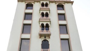 A multi-story building with a central entrance, arched windows, and decorative elements. - Hotel Golden Ram Vilas (Jaipur)