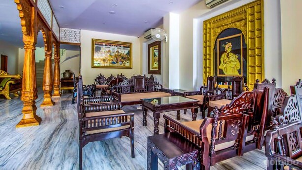 A traditional room with wooden furniture, a large ornate mirror, and a ceiling fan. - Hotel Golden Ram Vilas (Jaipur)