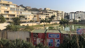 Un hotel de varios pisos con balcones, una zona de piscina y un letrero que dice 'Bambi Ice Cream Parlour'.