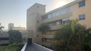 Un edificio de varios pisos con fachada plana, un cartel que dice "Boulevard" y un sendero que conduce a la entrada.
