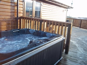 A wooden deck with a hot tub.