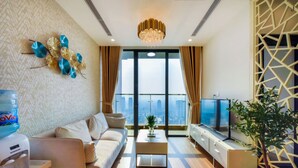 Una sala moderna con sofá, mesa de centro, televisor y decoración de pared.