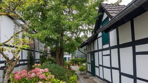 A traditional half-timbered building with a garden pathway. - Haus in Bewegung (Neunkirchen-Seelscheid)