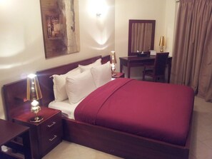 Minibar, escritorio, cortinas blackout y tabla de planchar con plancha