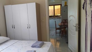 Un dormitorio con cama, armario y vista a un comedor.