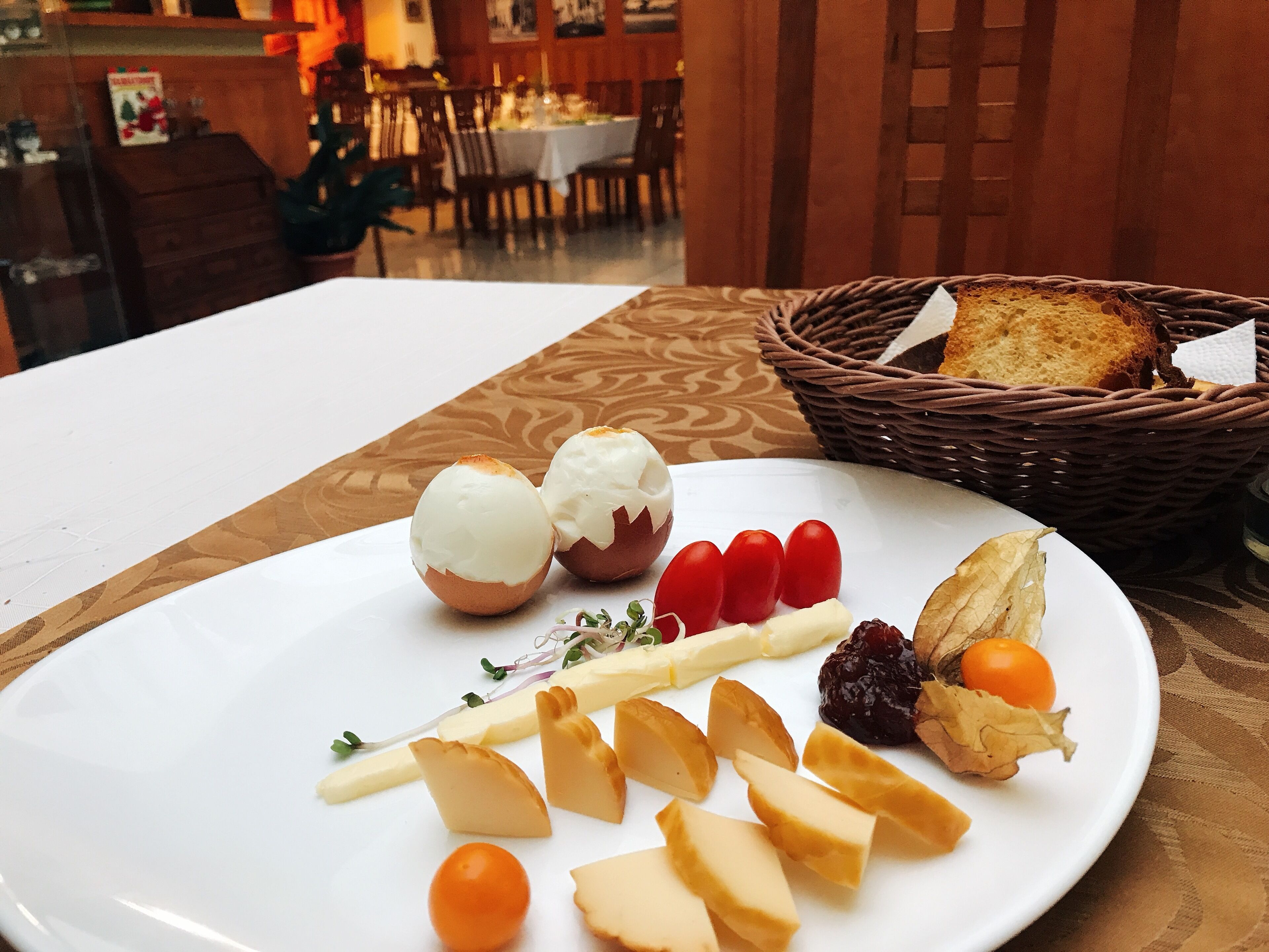 Una mesa con un plato de comida, que incluye queso, tomates y pan.
