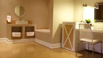A bathroom with a sink, mirror, and chair.
