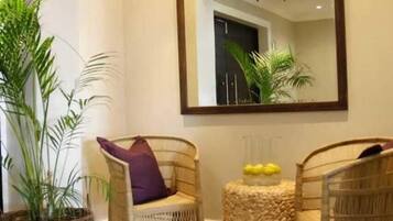 A room with wicker chairs, a large mirror, and a potted plant.