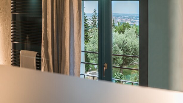 A modern bathroom with a large window, a towel rack, and a shower curtain. - Cà Toresele Relais Osteria Garden (Verona)