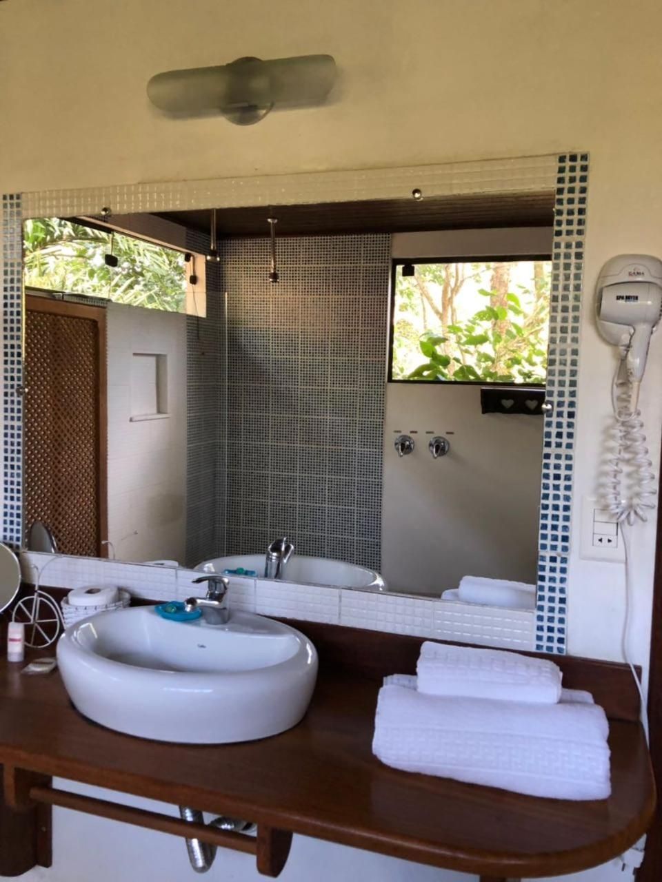 A bathroom with two sinks, a mirror, a hairdryer, and a towel rack.