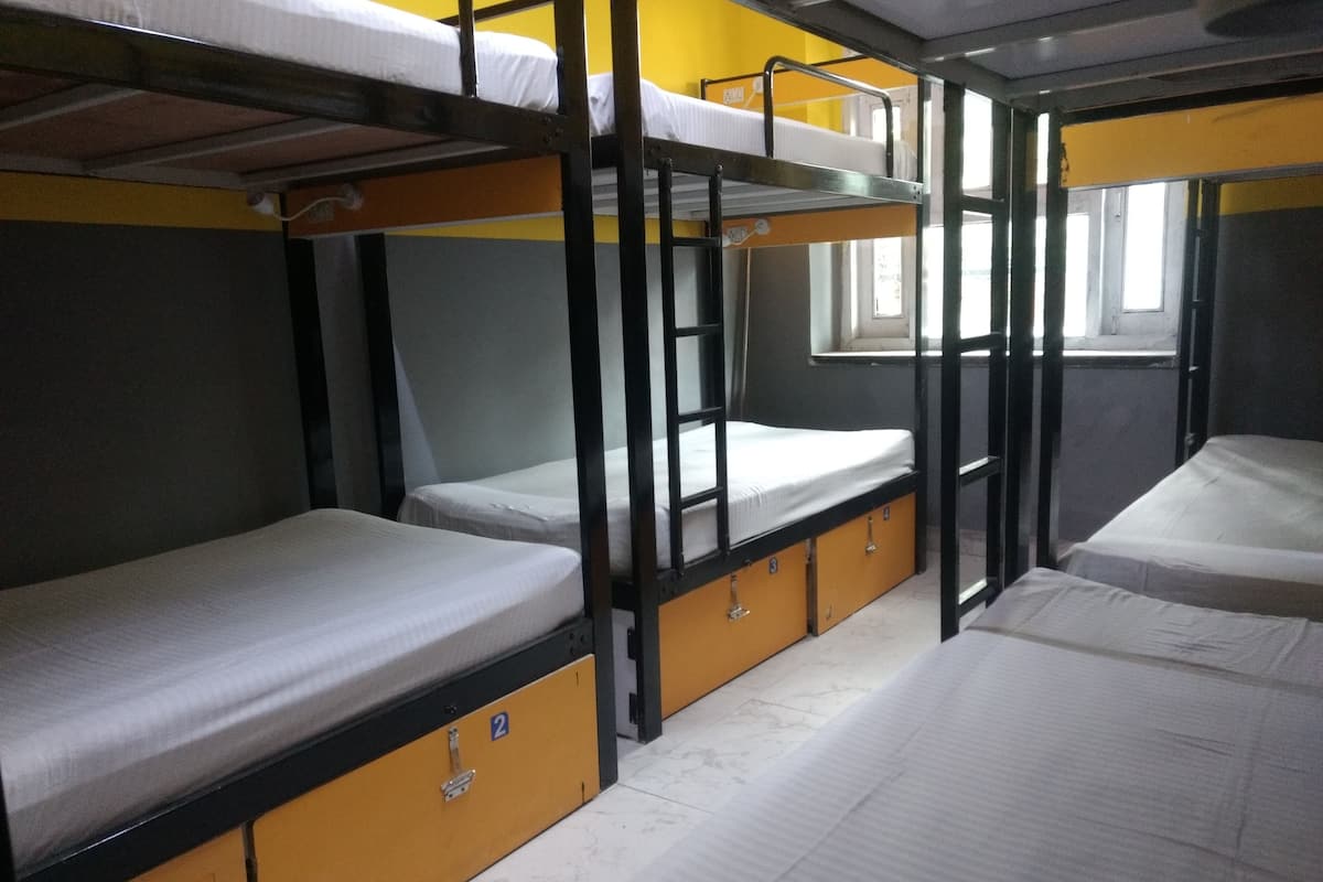 Dormitorio con literas, ventana, puerta y suelo de baldosas.