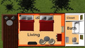 Un espacio habitable de dos habitaciones con un sofá rojo, dos camas, una mesita y un televisor. Cuenta con un baño independiente con inodoro, lavabo y ducha.