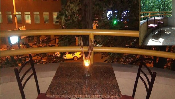 Ein Tisch mit zwei Stühlen, einer Kerze und einem Geländer.
