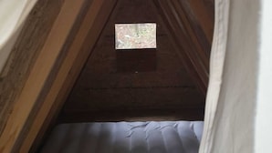 A narrow attic room with wooden beams and a small window. - Robinson camp Val Kavran (Kavran)