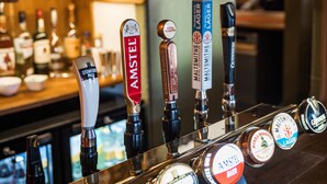 Een bar met meerdere biertappen, waaronder merken zoals Amstel en Malmsteen's Lager.