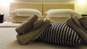 A hotel room with a double bed, two bedside lamps, and a headboard with a light fixture.