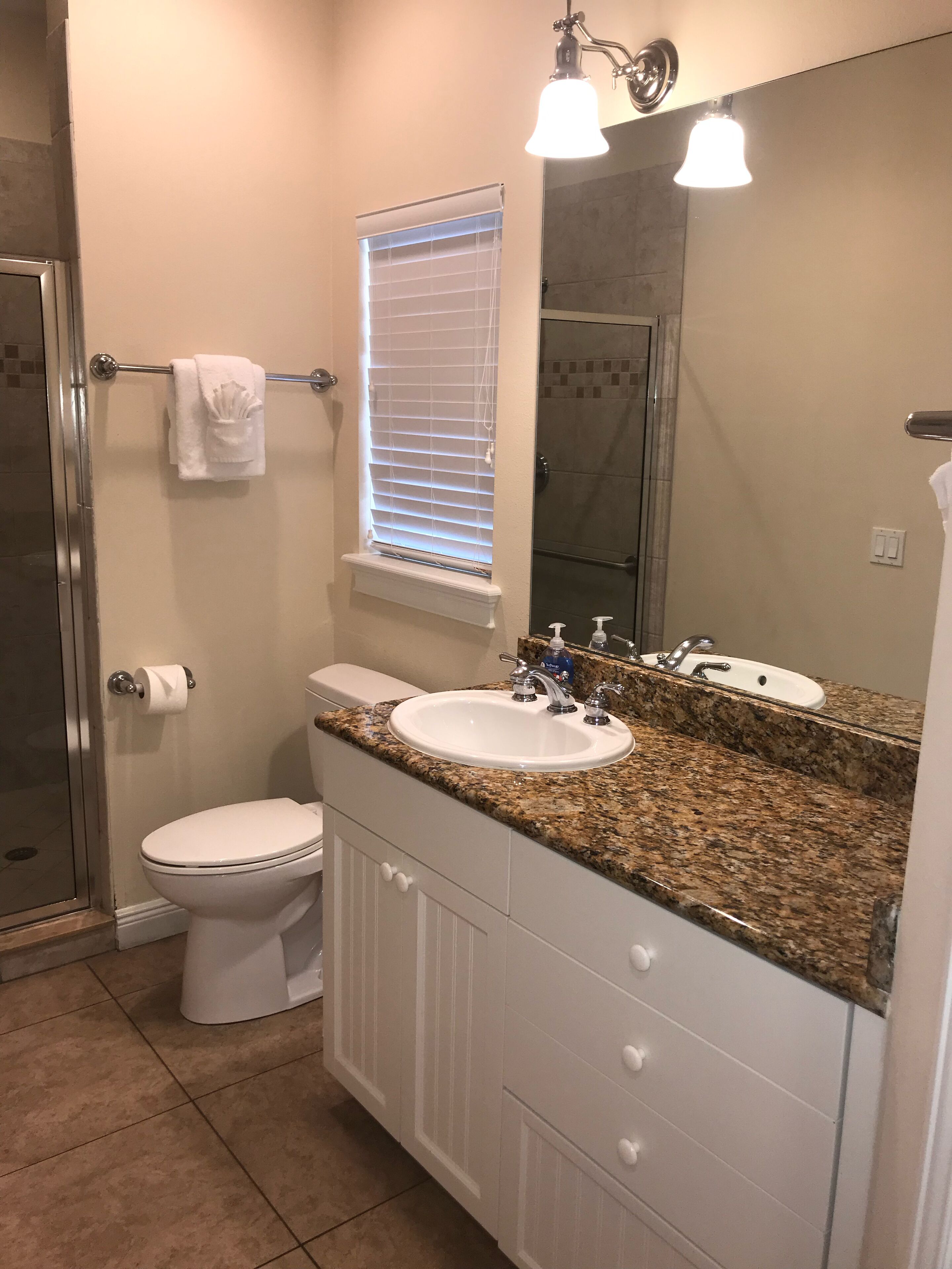 A bathroom with a toilet, sink, and shower.