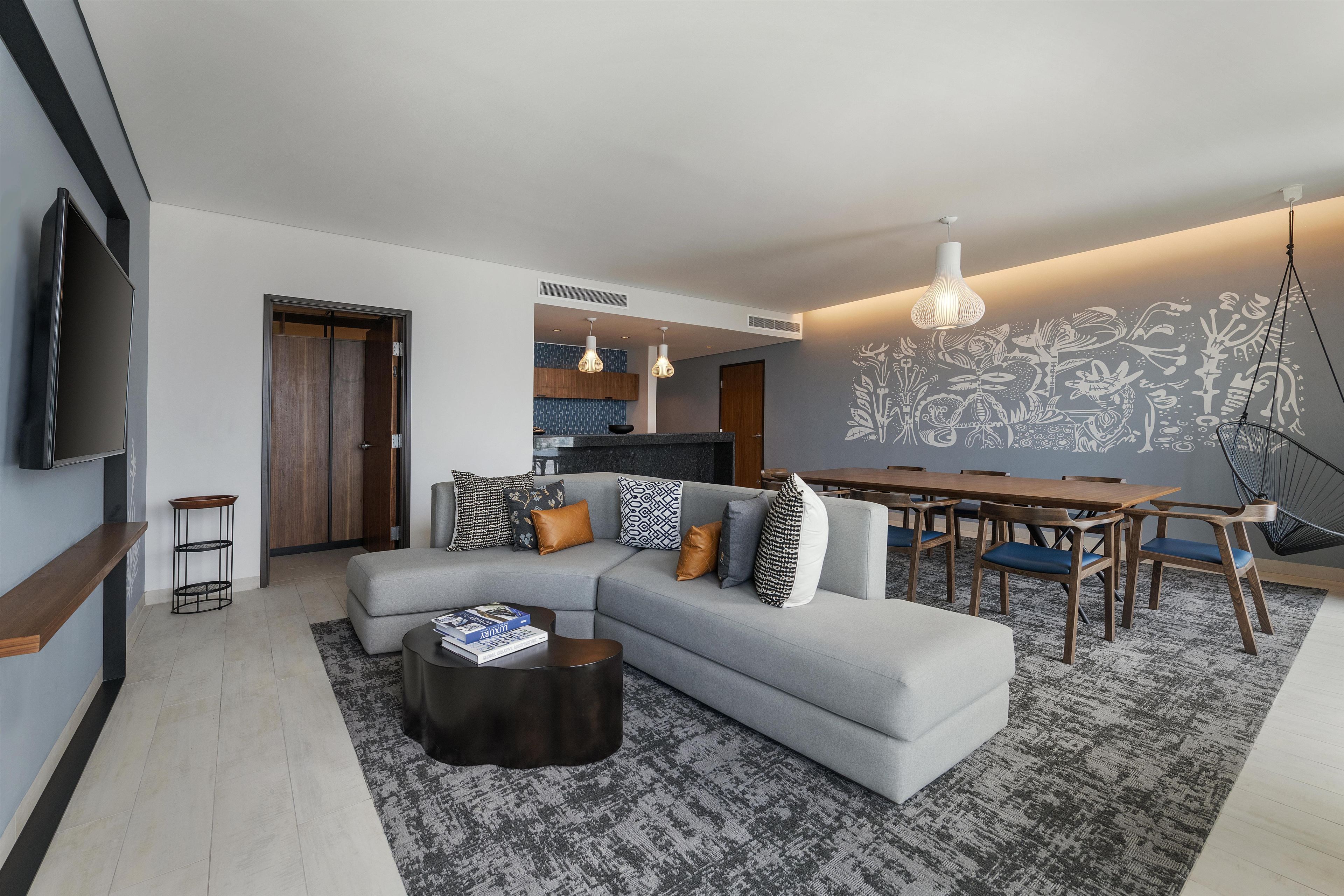 Una sala de estar moderna con un sofá seccional, una mesa de centro y un comedor con mesa y sillas.