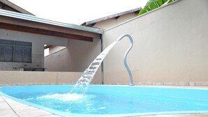 A swimming pool with a water fountain feature. - HOUSE WITH HEATED POOL Solar, air conditioning, Wi-Fi, and TV with Netflix! Sleeps 13 people (Olímpia)