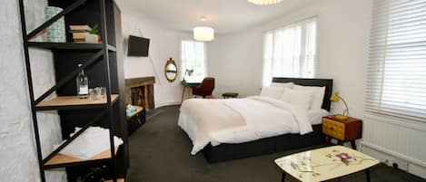 A bedroom with a bed, a bookshelf, a desk, and a chair.