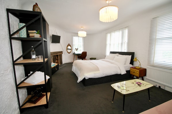 A bedroom with a bed, a bookshelf, a desk, and a chair.