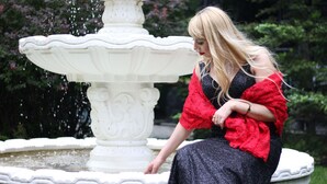 A person sitting by a white ornate fountain in a garden. - Mandarin ClubHouse (Kharkiv)