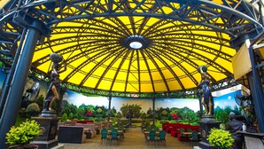 An outdoor café with a yellow dome roof, seating area, and statues. - Mandarin ClubHouse (Kharkiv)