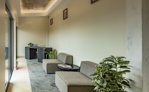 A modern hotel lobby with a stone floor, a reception desk, and seating areas. - Angulo House (Sal)