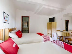 A hotel room with two beds, a desk, a chair, a wardrobe, and a television. - OYO Imperial Parque Hotel (Nova Petropolis)