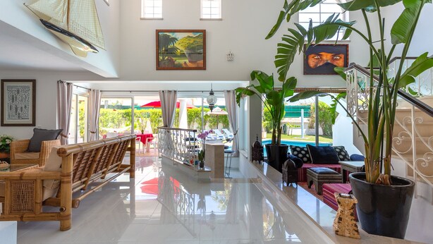 A spacious hotel lobby with a wooden bench, a dining area, and a view of the pool and garden. - A unique house in a fabulous position near  Galé beach (Gale)