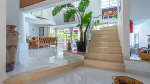 A spacious lobby with a staircase, a large plant, and a traditional woven basket. - A unique house in a fabulous position near  Galé beach (Gale)