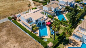 An aerial view of a resort with multiple buildings, a central swimming pool, and surrounding greenery. - A unique house in a fabulous position near  Galé beach (Gale)