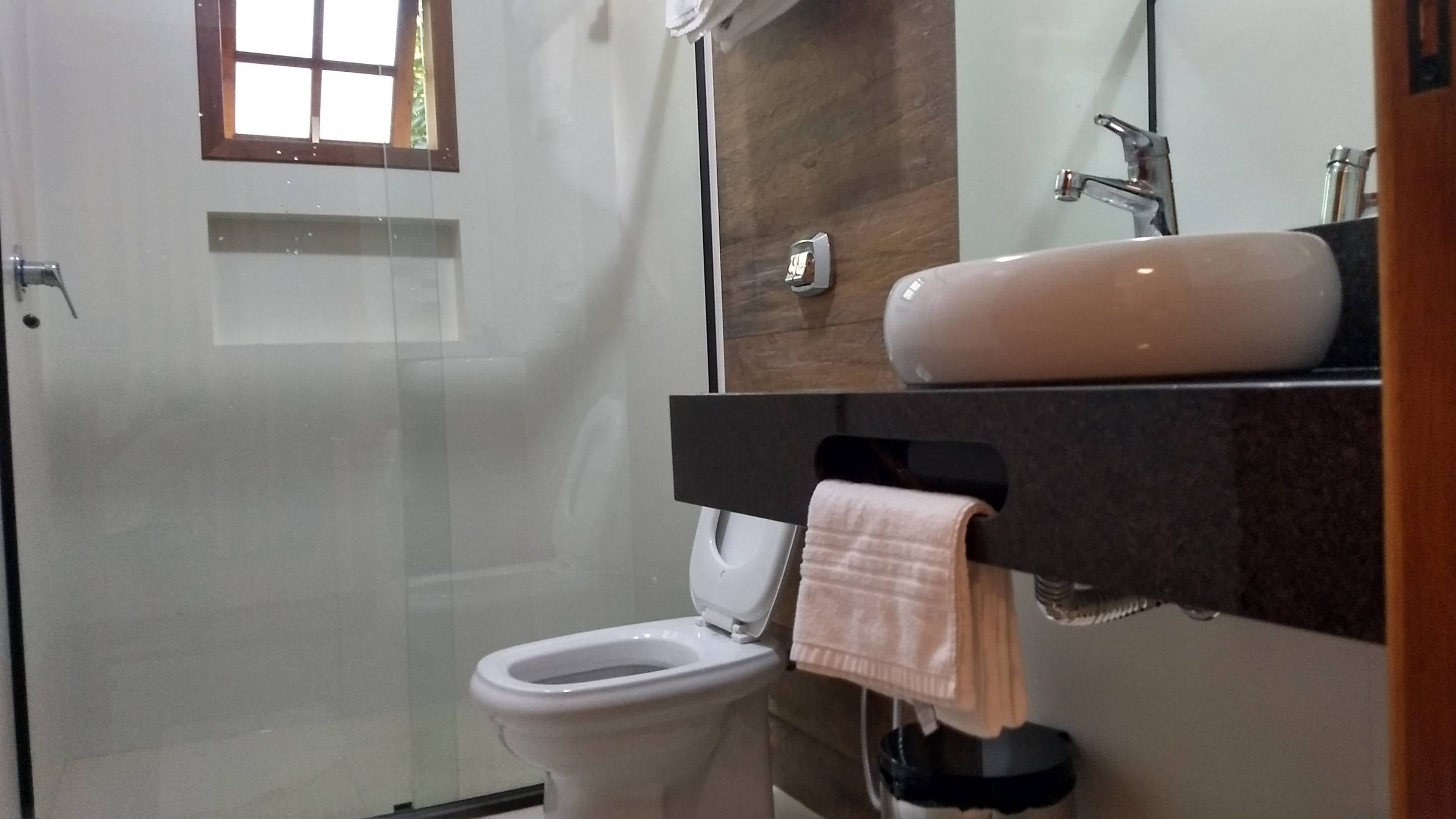 Ein Badezimmer mit Toilette, Waschbecken und Duschbereich.