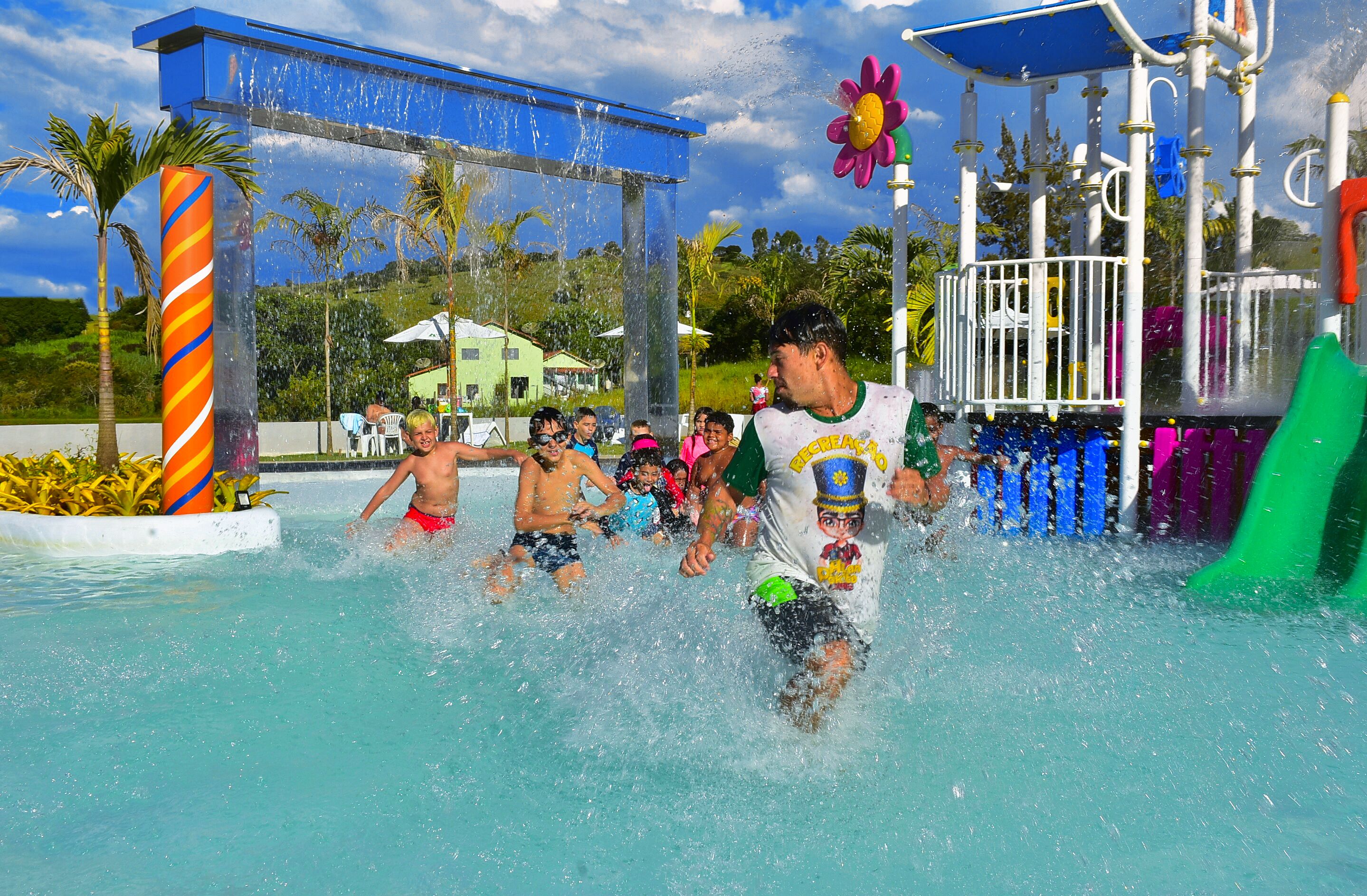 A water park with a play structure and a pool.