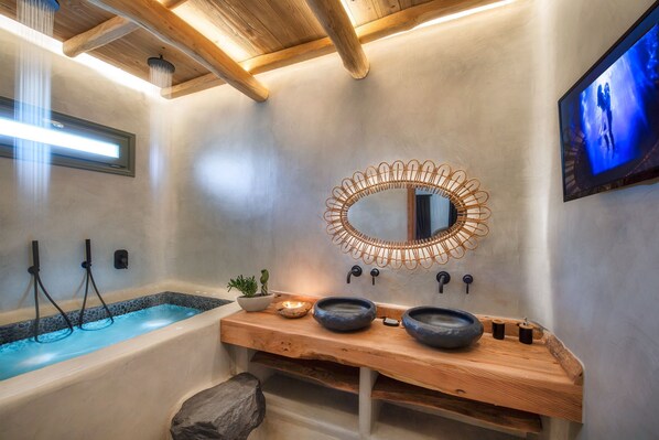Une salle de bain moderne avec un meuble-lavabo en bois, un grand miroir et une baignoire.