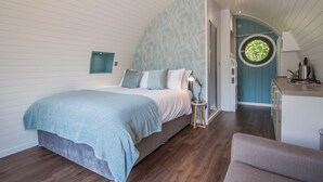 Een slaapkamer met een bed, nachtkastje en een raam.